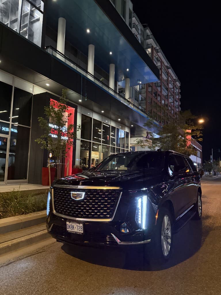 Black Escalade chauffeur SUV at night in downtown Toronto
